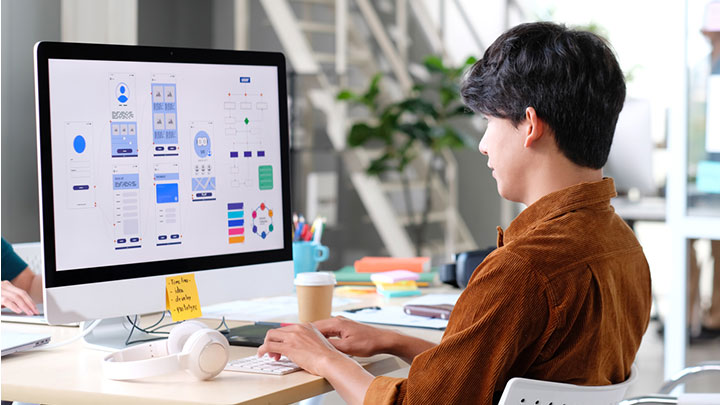 A designer creates a mockup on a large screen.